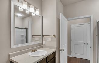 a bathroom with a sink and a mirror and a door