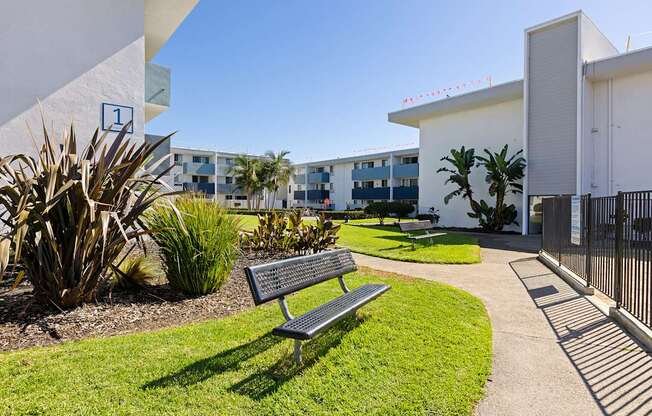 A bench is situated in a grassy area in front of a building.