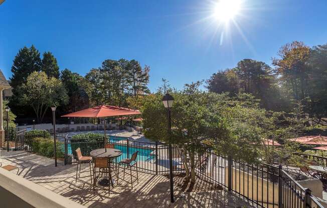 a patio with tables and chairs and a swimming pool at Radbourne Lake Apartments, North Carolina, 28269