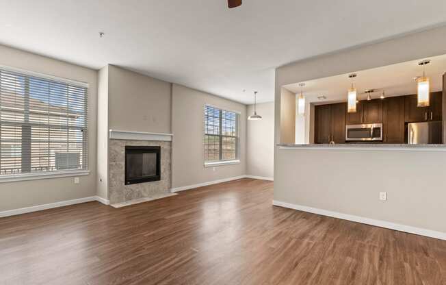 a living room with a fireplace and a kitchen in the background