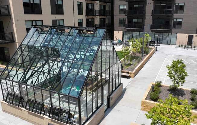 an aerial view of a building with a glass facade and a courtyard