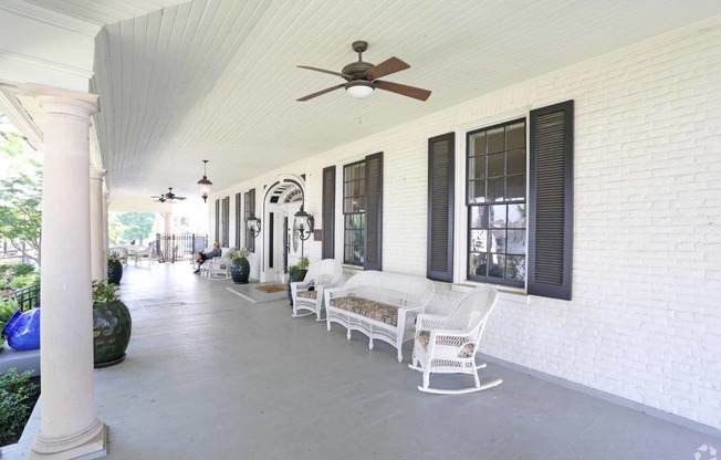 a porch with wicker furniture and a ceiling fan