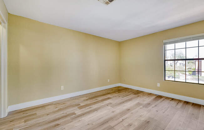an empty attic with a wooden floor and a window
