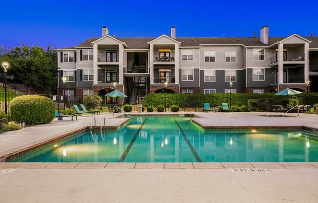 A large apartment complex with a pool in front.