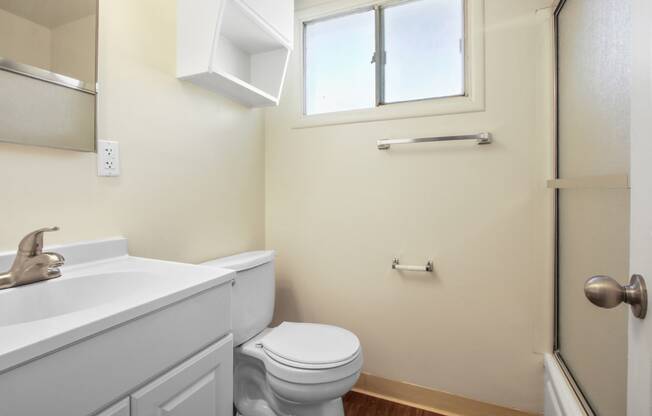 Bathroom with shower and tub combo at the right, single vanity with white cabinet