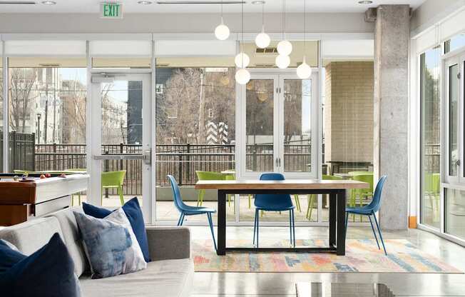 A brightly lit room with a couch, chairs, and large table.