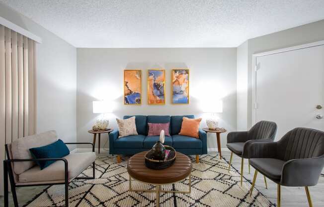 a living room with a blue couch and three chairs