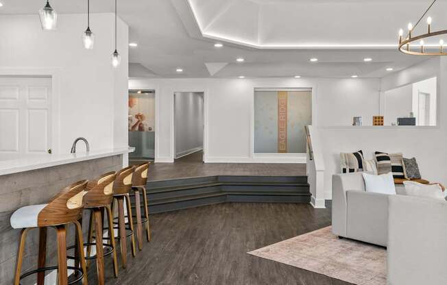 A modern living room with a bar area and a grey sofa.