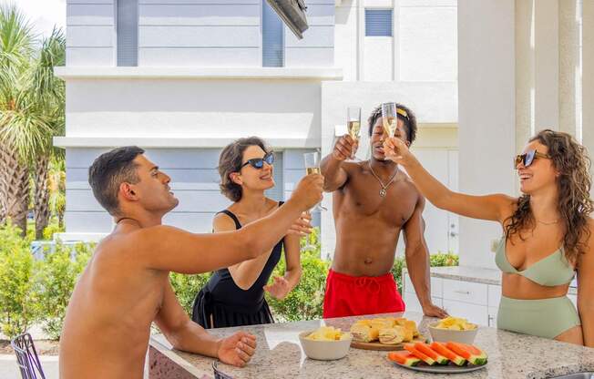 A group of people toasting with champagne at a barbecue.at Icon One, Florida, 32114
