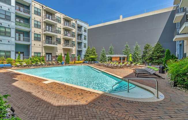 a swimming pool with an apartment building in the background