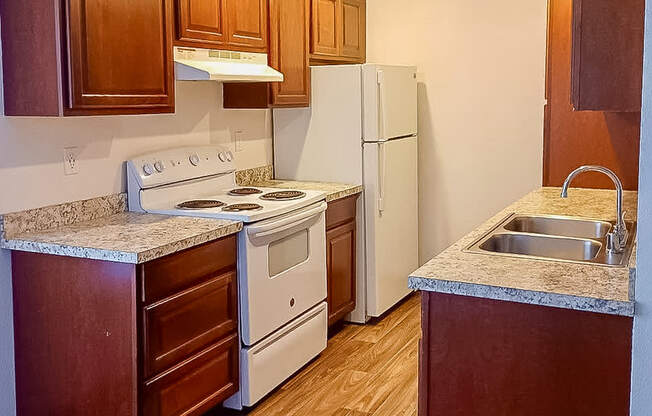 A kitchen with wooden cabinets and a white refrigerator.