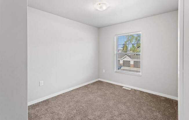 a large carpeted bedroom with overhead lighting and a window at Muskego School