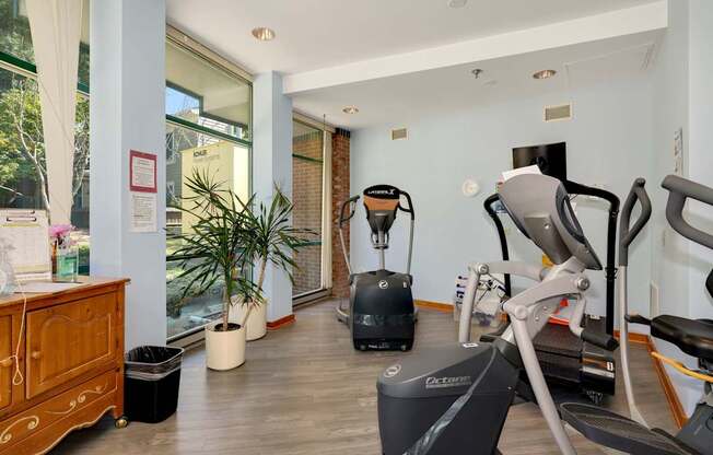 a gym with a treadmill and exercise equipment in the corner