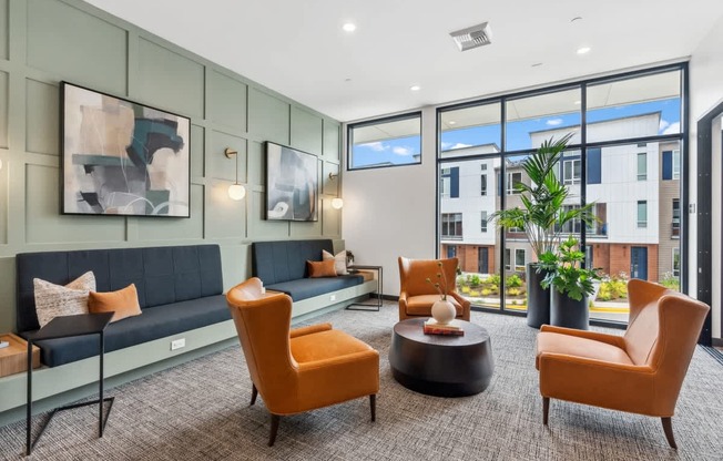 A modern living room with a grey sofa, orange chairs, and a coffee table.