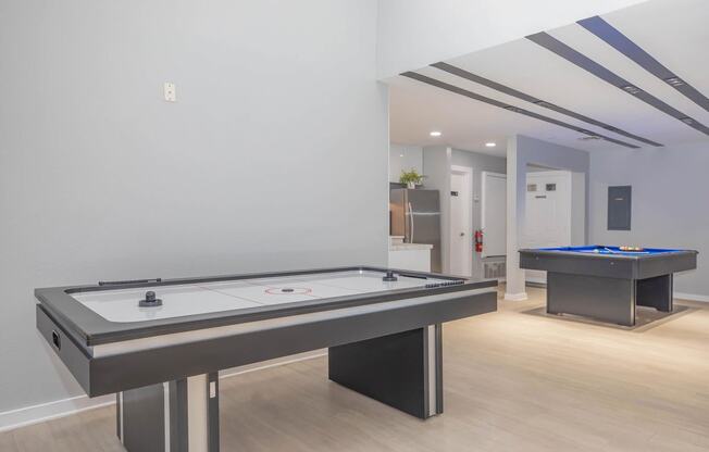 a game room with two pool tables and a foosball