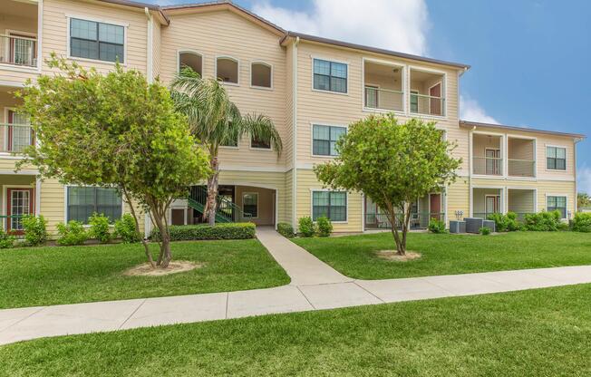 a house with a lawn in front of a brick building
