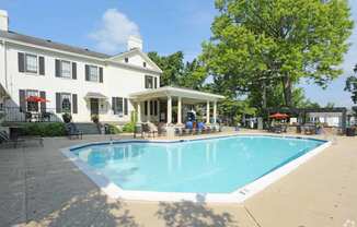 a swimming pool with a white building in the background