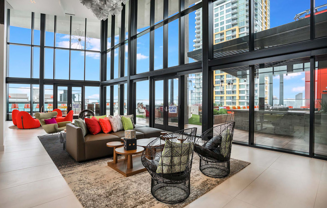 couch and chairs in front of ceiling high windows