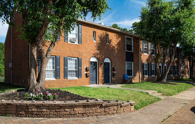 a large brick building with a tree in front of it