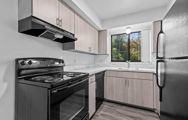 a kitchen with gray cabinets and a black stove top oven