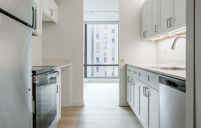 A kitchen with white appliances and cabinets.