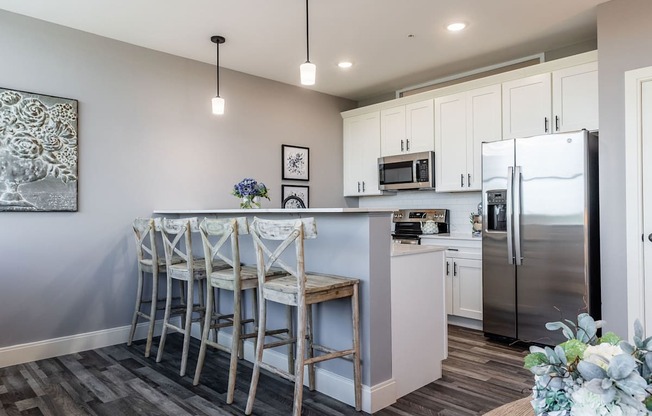 A kitchen with a bar area and a refrigerator.