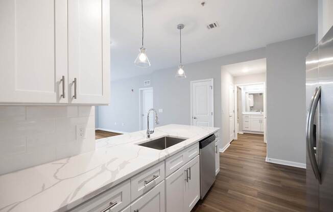 A kitchen with white cabinets and a marble countertop. at Harbor Pointe, New Jersey, 07002