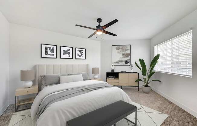 A bedroom with a bed, nightstands, and a ceiling fan.