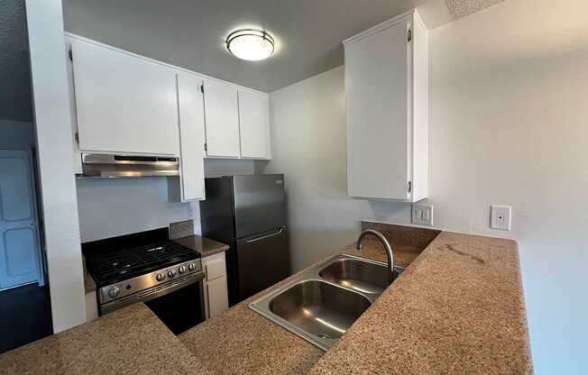A kitchen with a sink and a stove top oven.