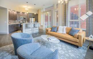 a living room and kitchen with blue chairs and a couch