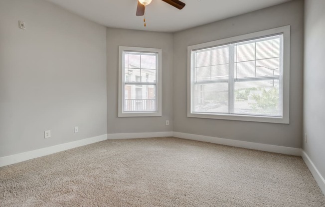 bedroom with carpeted flooring, windows, and ceiling fan