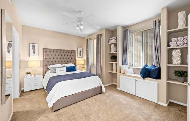 A bedroom with a large bed and a ceiling fan. at The Fairways by Picerne Apartments, Las Vegas