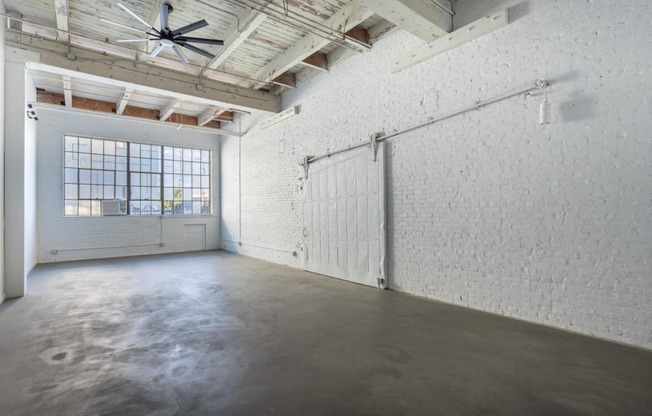 an empty room with a garage door and concrete floor