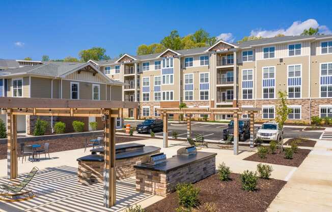 an outdoor patio with a firepit and picnic table at the enclave at woodbridge apartments in at The Bend Arbordale, Williamsburg