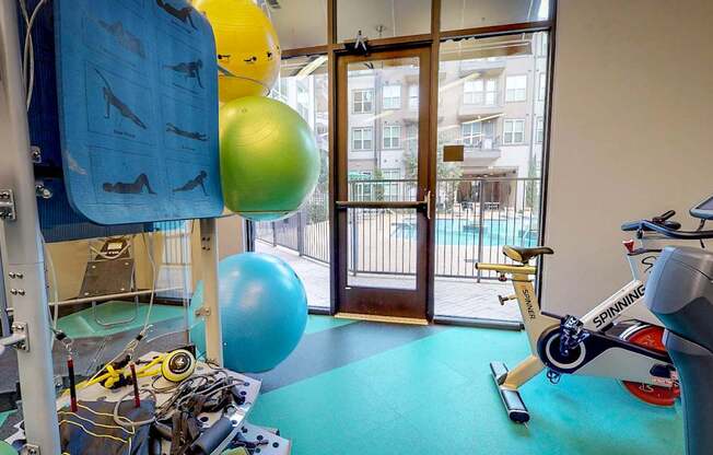 A gym with a blue mat and a variety of equipment including a treadmill.