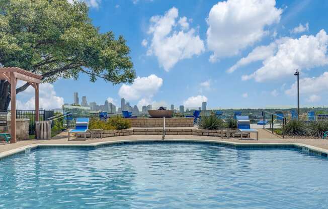 a pool with a view of the city in the background