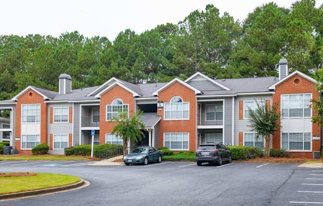 an apartment building with cars parked in a parking lot at Twenty35 at Timothy Woods, Athens, Georgia