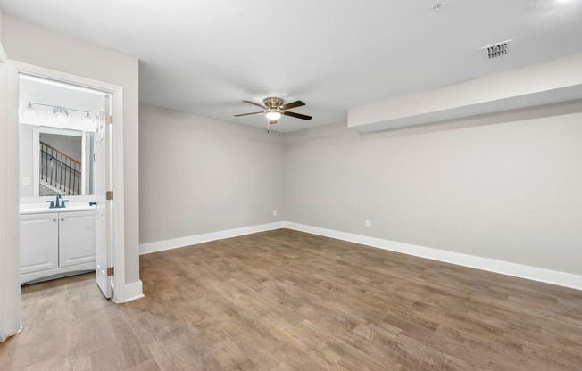 an empty living room with white walls and a ceiling fan at Crogman School Lofts, Atlanta, 30315