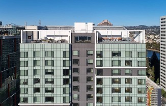A modern building with glass windows and balconies is seen from a high vantage point.