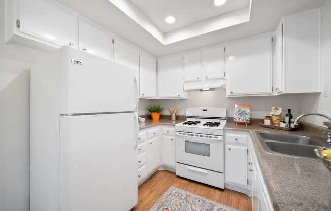 a kitchen with white cabinetry and white appliances