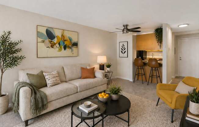 A living room with a couch, a chair, a table, and a painting on the wall.