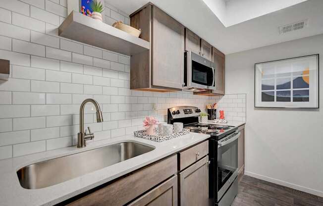 A kitchen with a white sink and black oven.