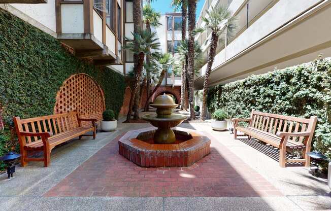 a courtyard with a fountain and benches