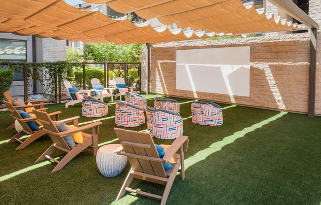 A patio with a white ball and chairs under a canopy.