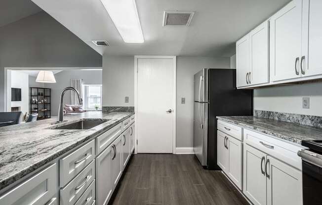 A modern kitchen with white cabinets and a black refrigerator