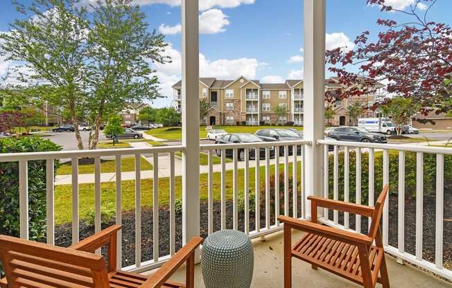 a porch with two wooden benches and a parking lot