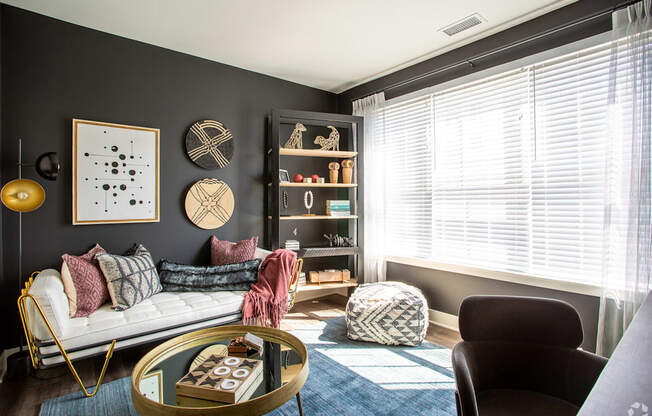 A living room with a white sofa, a coffee table, and a bookshelf.
