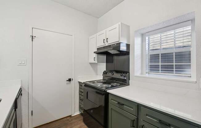 A kitchen with a stove, oven, and cabinets.
