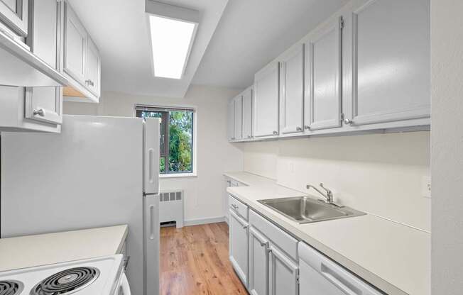 a white kitchen with white cabinets and white appliances