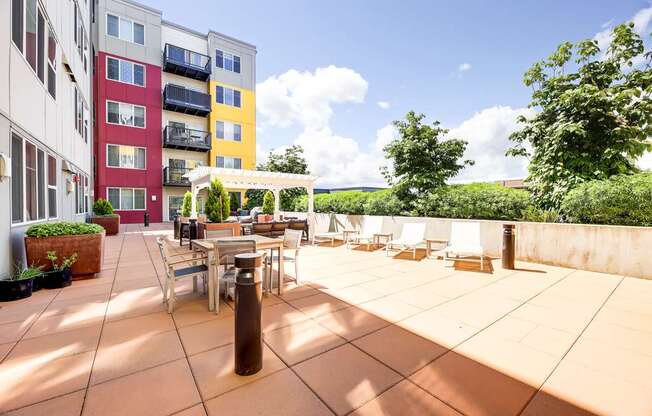 A patio with a table and chairs is surrounded by apartment buildings.